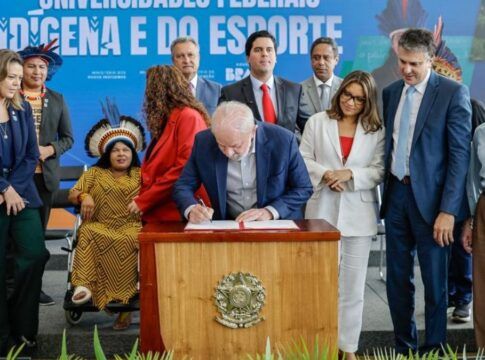 Lula assinando projeto de lei em palanque com ministros em volta