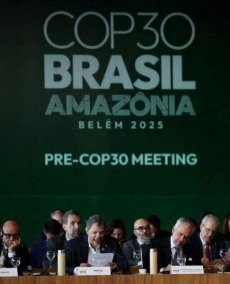Políticos sentados em evento de abertura na COP30. Ao fundo, uma parede verde com os dizeres COP 30-BRASIL-AMAZÔNIA-PRE-COP30 MEETING