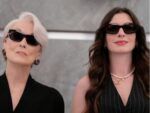 Anne Hathaway e Meryl Streep vestidas de preto no elevador.