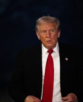 O presidente dos Estados Unidos, Donald Trump, vestindo um terno com um fundo escuro.