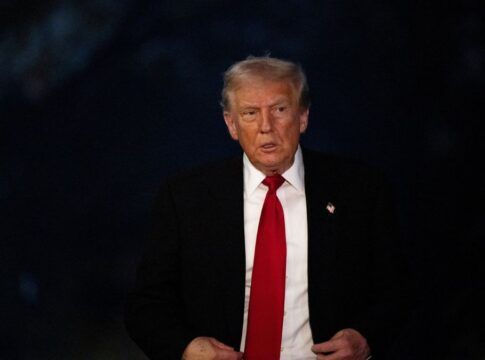 O presidente dos Estados Unidos, Donald Trump, vestindo um terno com um fundo escuro.