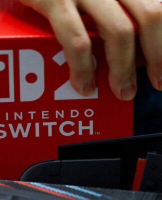Mão segurando uma caixa contendo um Nintendo Switch 2