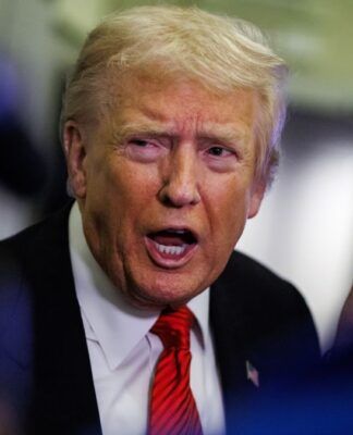 Close up de Trump usando terno azul, gravata vermelha e falando em tom enérgico