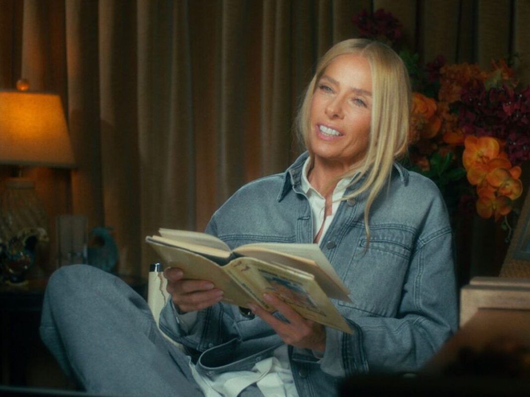 Adriane Galisteu em seu documentário segurando livro que ela escreveu na época da morte do piloto