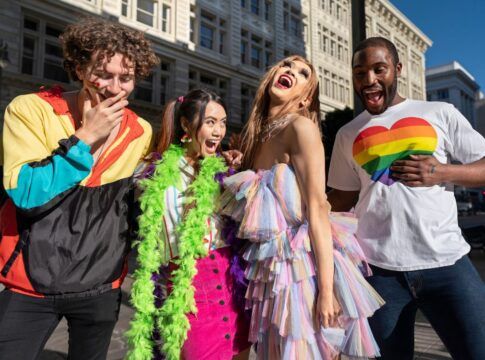 Em imagem ilustrativas há algumas pessoas com roupas coloridas e felizes.