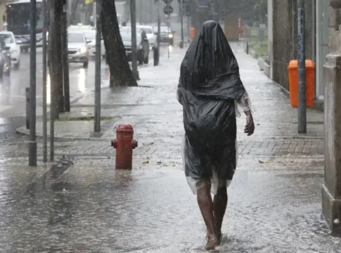 Uma pessoa caminha na calçada em meio a fortes chuvas no Brasil