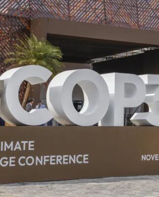 Imagem mostra o letreiro da COP30, em Belém, com fonte branca sobre uma bancada marrom.
