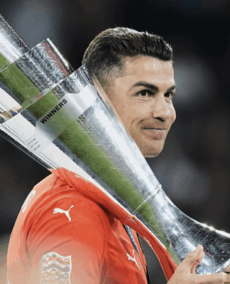 Cristiano Ronaldo, com a camisa de Portigal, segurando o troféu da Nations League sobre os ombros.