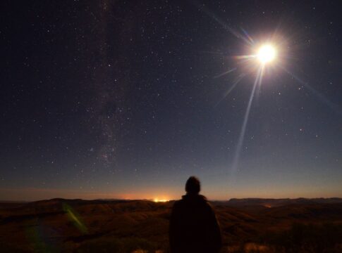 Em imagem ilustrativa, pessoa observa um eclipse se formando