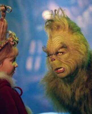 Na foto há um homem pintado de verde e com pelos colados no corpo. Há também uma menina loiro com um penteado.