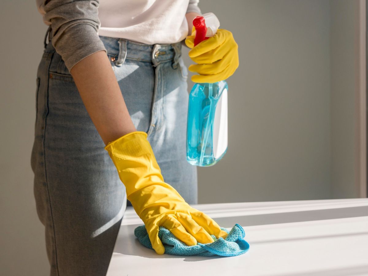 close de uma mulher limpando uma superfície