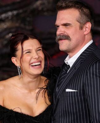 Imagem mostra os atores Millie Bob Brown e David Harbour abraçados e rindo durante o Stranger Things Day.
