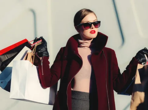 Uma mulher carrega sacolas de compras, Black Friday, promoções