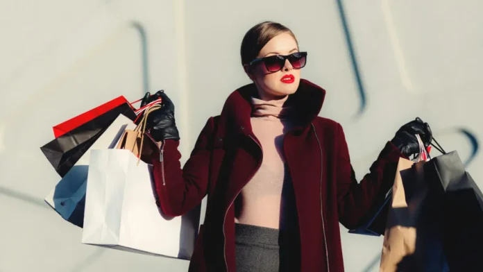 Uma mulher carrega sacolas de compras, Black Friday, promoções