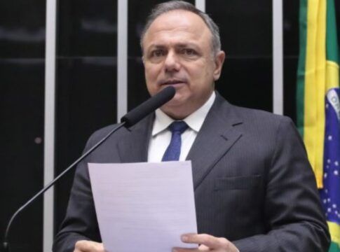 A foto é um retrato em plano médio-fechado de Eduardo Pazuello, ex-Ministro da Saúde e atualmente deputado federal, no plenário da Câmara dos Deputados.