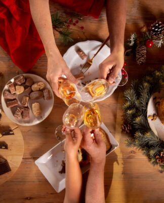 Em imagem ilustrativa, família brindam a mesa de Natal com champagne