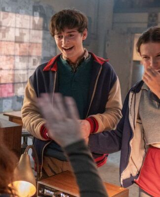 Esta é uma imagem colorida, em ambiente interno, que captura um momento de aparente alegria e intensa atividade de investigação, tipicamente associado à série Stranger Things.