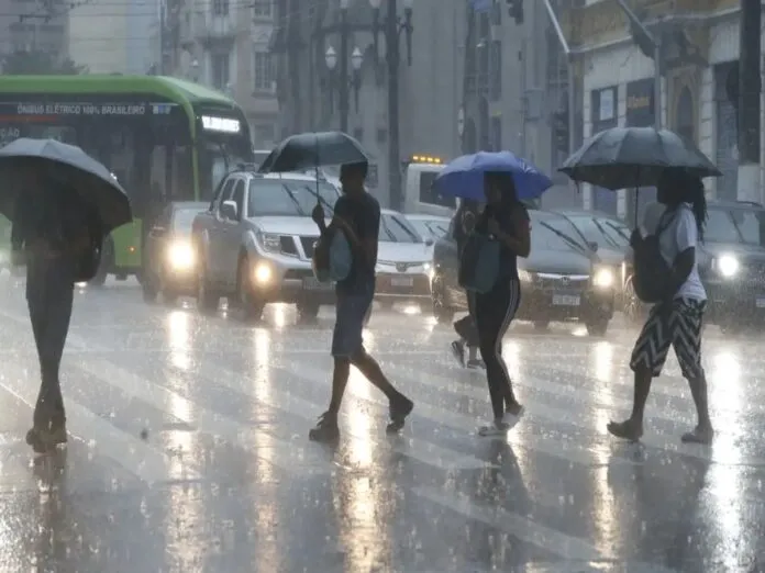 Imagem de pessoas andando na chuva em São Paulo