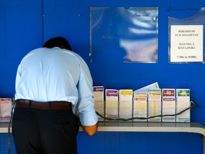 Imagem de um homem fazendo aposta em uma lotérica