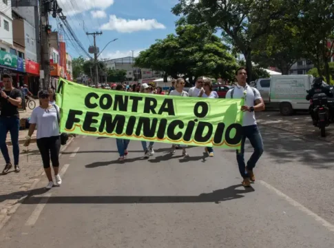 mulheres segurando faixa escrito 
