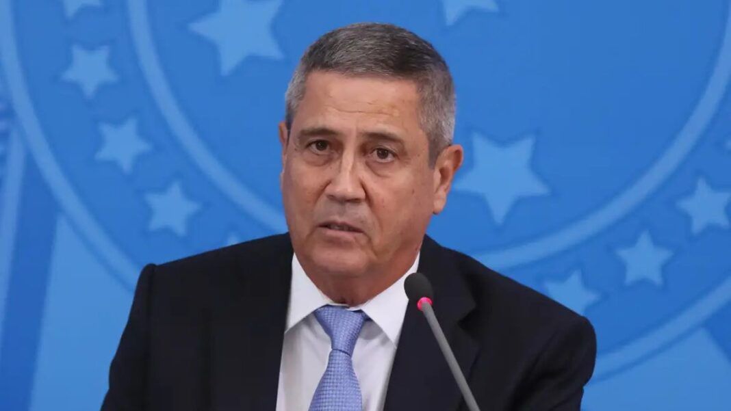 General Braga Netto fala ao microfone com símbolo militar em azul ao fundo