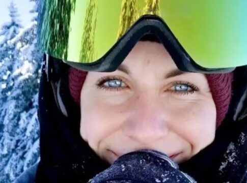 Foto aproximada do rosto da vítima, que veste trajes de proteção para caminhar na neve; se vê na imagem apenas seus olhos azuis e seu sorriso