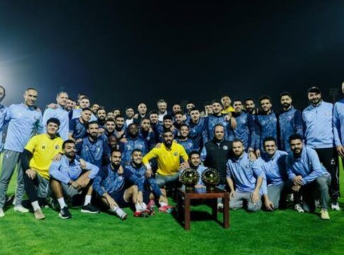 Elenco do Pyramids FC posando com troféu durante treino