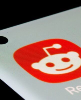 Dedo prestes a pressionar o ícone do aplicativo Reddit
