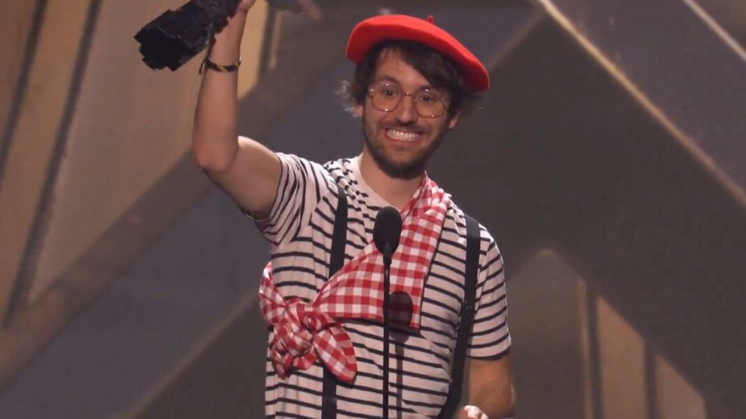 Homem vestido com roupas de mímico levantando troféu