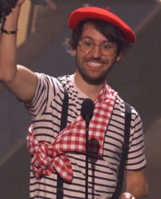 Homem vestido com roupas de mímico levantando troféu