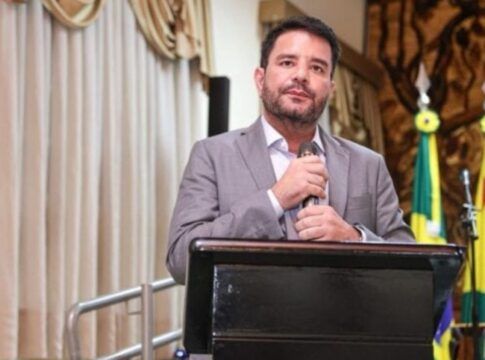 Governador do Acre segura o microfone com as duas mãos durante evento