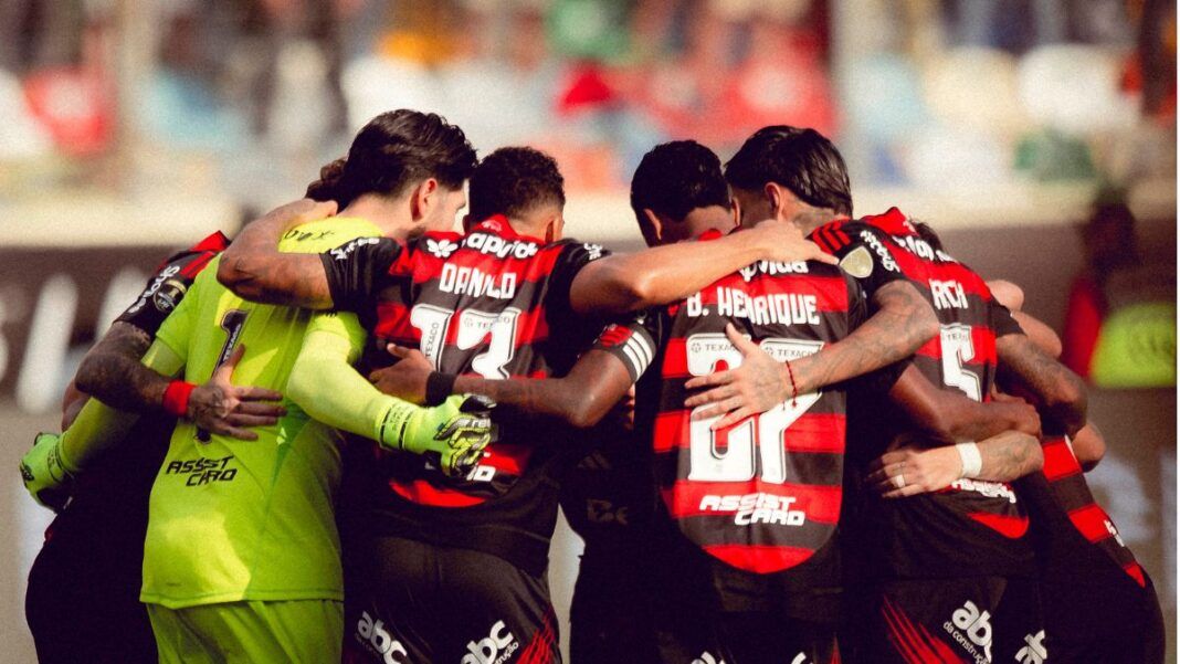 Atletas do Flamengo reunidos em círculo antes da partida contra o Palmeiras