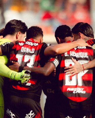 Atletas do Flamengo reunidos em círculo antes da partida contra o Palmeiras