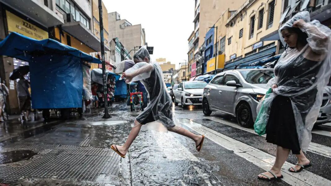 Pessoas de capa de chuva em São Paulo