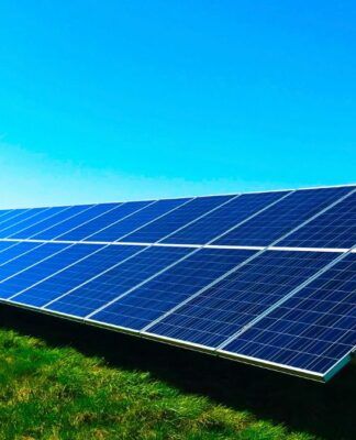 Placas de energia solar voltadas para o sol sobre um gramado