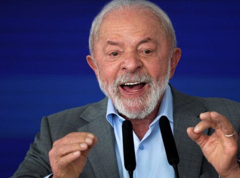 Lula gesticula com as duas mãos diante de microfone