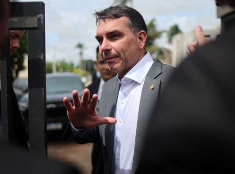 Flávio Bolsonaro faz gesto com a mão em entrevista à imprensa