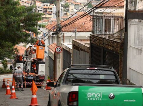 Carro da Enel faz atendimento em poste em rua de São Paulo