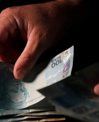 imagem de uma mão manipulando notas de dinheiro