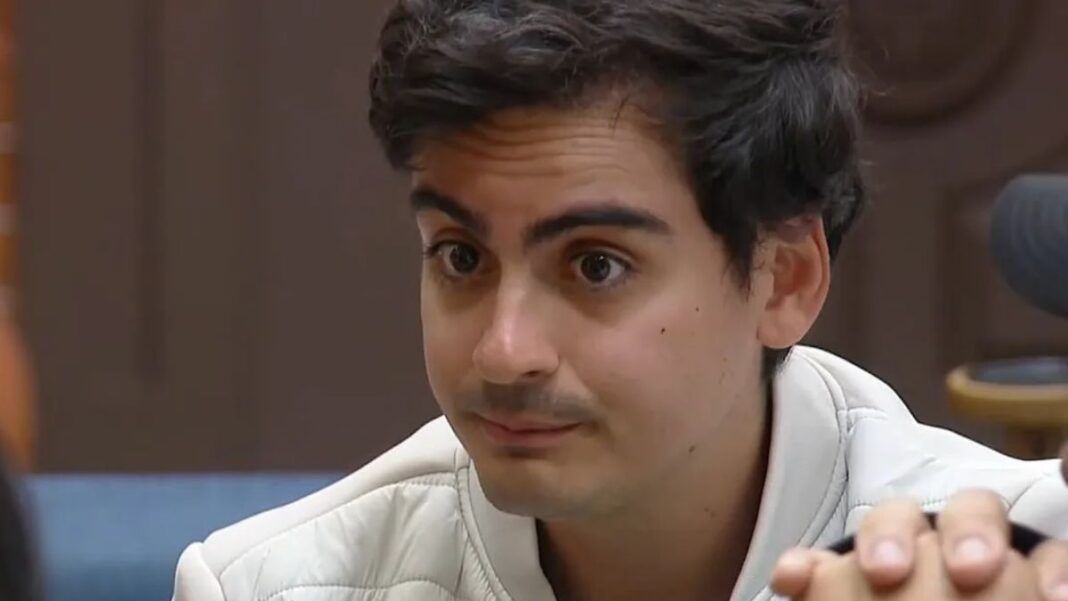 A foto apresenta um primeiro plano (close-up) do rosto de Dudu Camargo, capturado em um ângulo levemente lateral. Ele parece estar em meio a uma conversa ou entrevista em um ambiente interno.