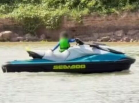 A imagem mostra uma criança muito pequena pilotando um jet ski em um corpo d'água, com o rosto borrado digitalmente para proteger sua identidade, conforme indicado pela nota do Conselho Tutelar sobre o episódio.