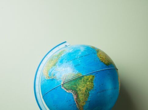 livros empilhados e um globo terrestre no topo