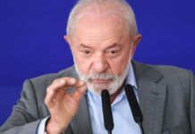 A imagem é um close-up que foca no rosto e na parte superior do tronco do presidente Luiz Inácio Lula da Silva, que está falando ou fazendo um pronunciamento.