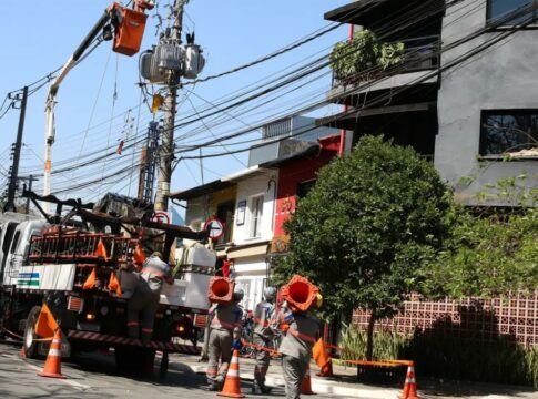 Funcionários da Enel consertam poste de luz