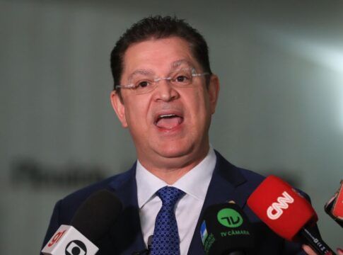 A foto apresenta um primeiro plano (close-up) do deputado Sóstenes Cavalcante durante uma entrevista ou declaração à imprensa em um ambiente interno. Ele está centralizado na imagem, voltado para a frente.