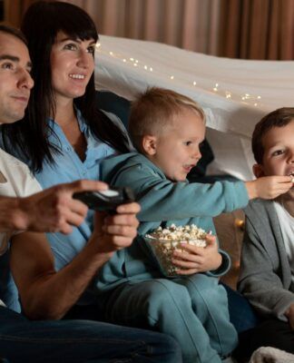 Em imagem ilustrativas família está pronta para assistir um filme em casa