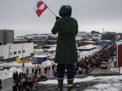 Mulher acena com uma bandeira da Groenlândia durante um protesto contra a exigência do presidente dos Estados Unidos, Donald Trump, de que a ilha no Ártico seja cedida aos EUA