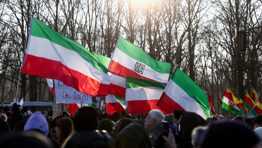Manifestantes seguram bandeiras durante uma marcha em apoio aos protestos em todo o Irã, em Berlim, na Alemanha