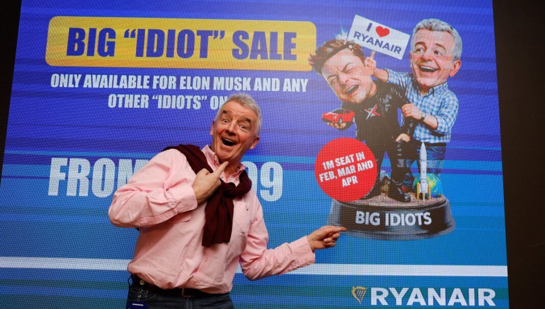 Michael O’Leary, CEO da Ryanair, posa em frente a uma tela que satiriza Elon Musk antes de entrevista coletiva sobre o embate com o bilionári