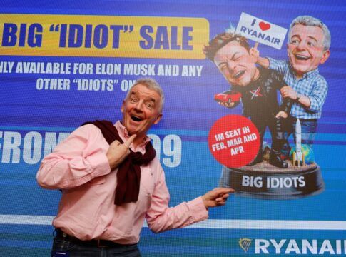 Michael O’Leary, CEO da Ryanair, posa em frente a uma tela que satiriza Elon Musk antes de entrevista coletiva sobre o embate com o bilionári